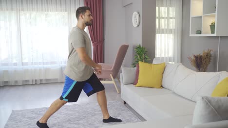 Young-sporty-male-exercising-in-living-room-interior.